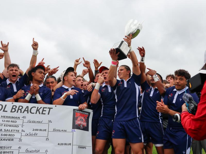 Charlotte Cardinals' Kemper Castro holds the Lee Kelly Trophy aloft. Photo Calder Cahill.