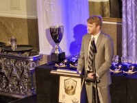 Connor Kelly accepts for his father. The Leee Kelly Trophy is in the background. Alex Goff photo.