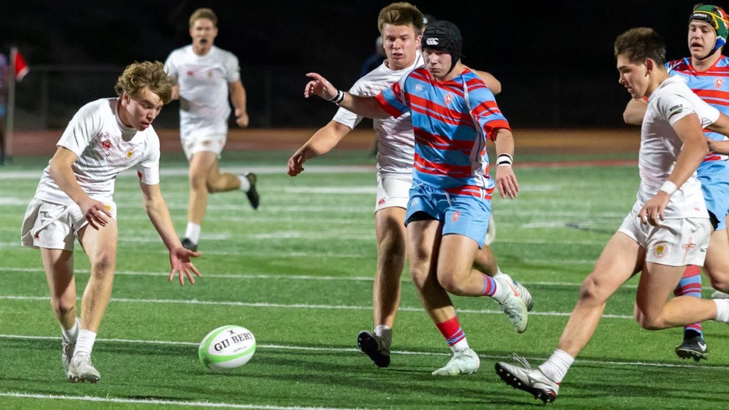 Cathedral Catholic, in white, chasing a loose ball vs Charlotte Catholic. Photo Dan Caple.